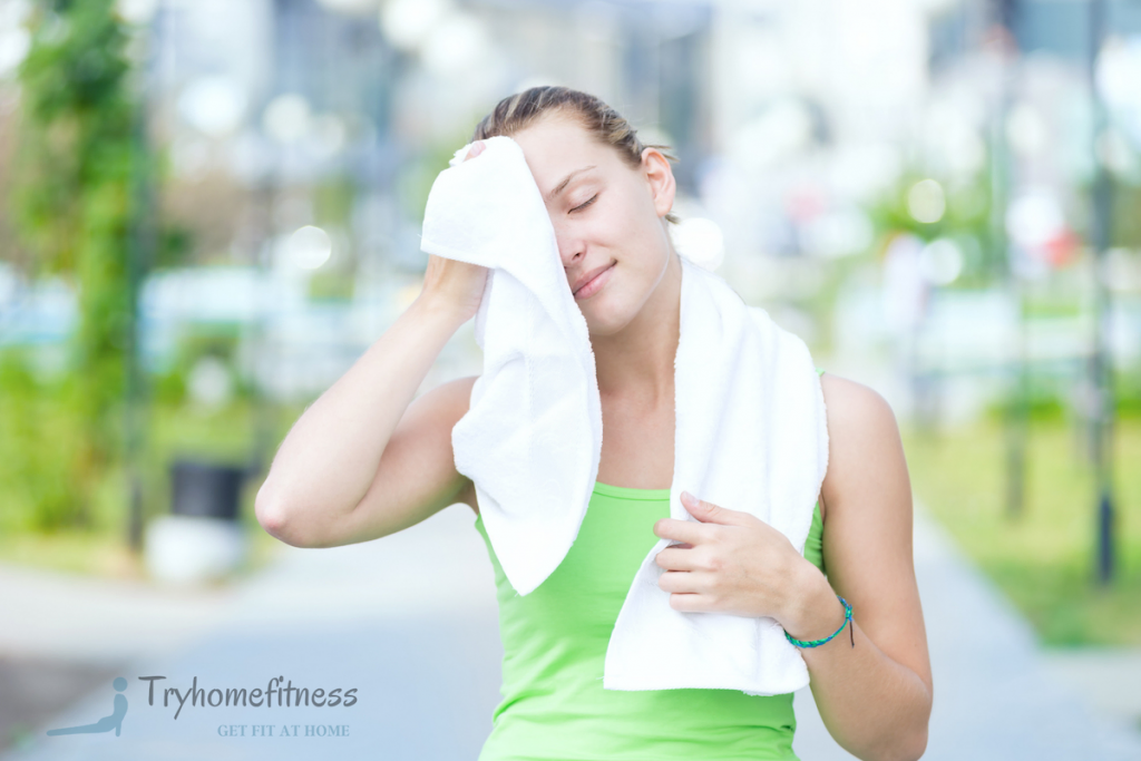 Girl using her best gym towel to swipe the sweat