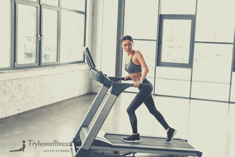 Girl on incline on a treadmill with tv