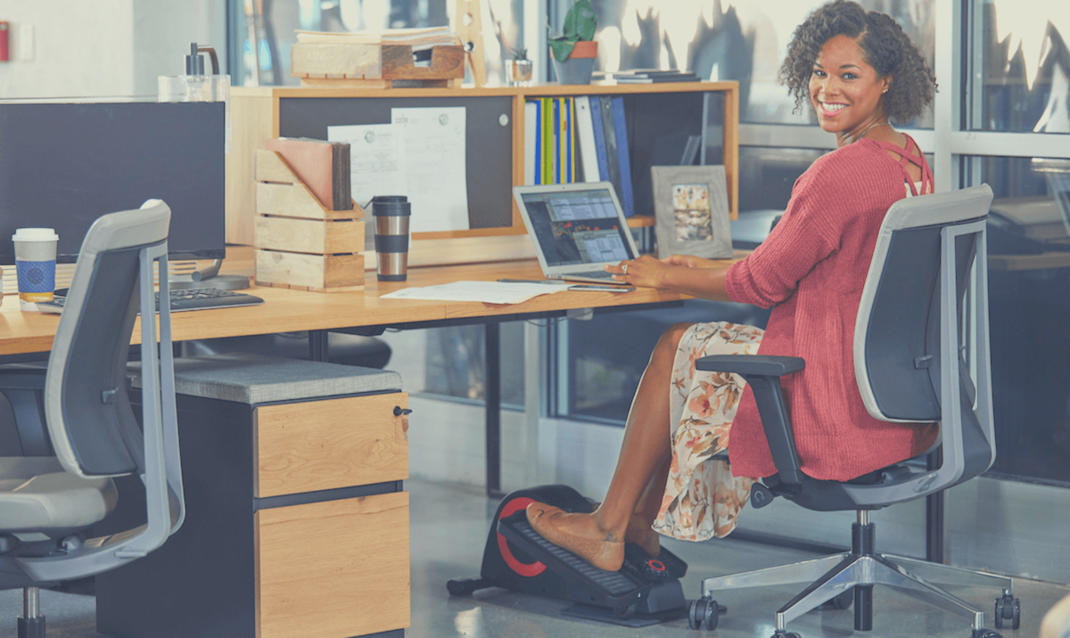 Woman at office with the best under desk elliptical