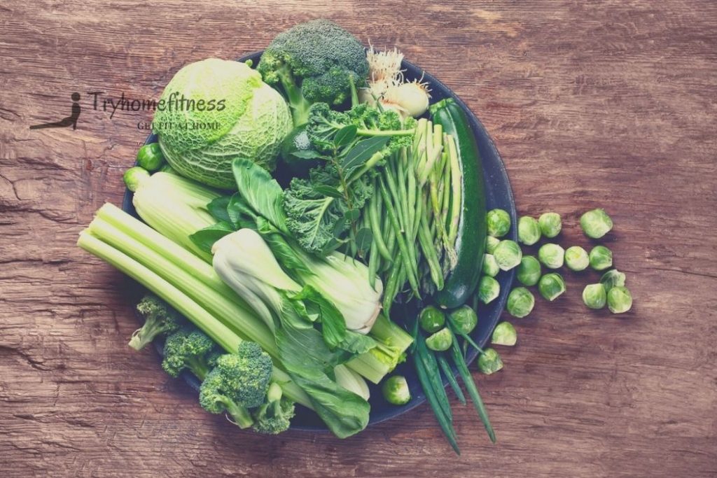 benefits of green leafy vegetables ona wooden backdrop