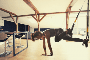 In loft space woman using trx