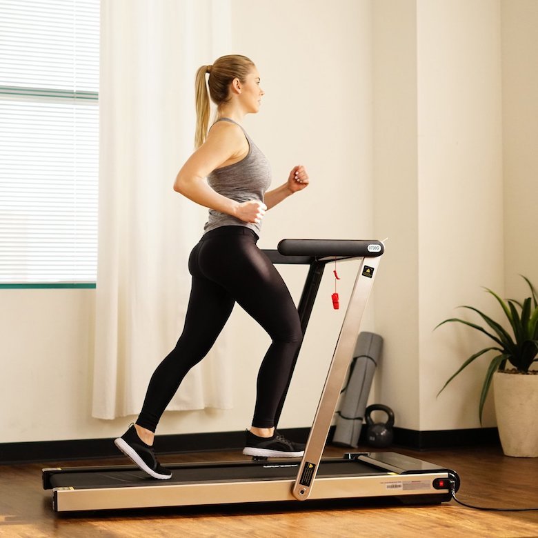 Girl in the front room running on our pick for the best under bed treadmill for value
